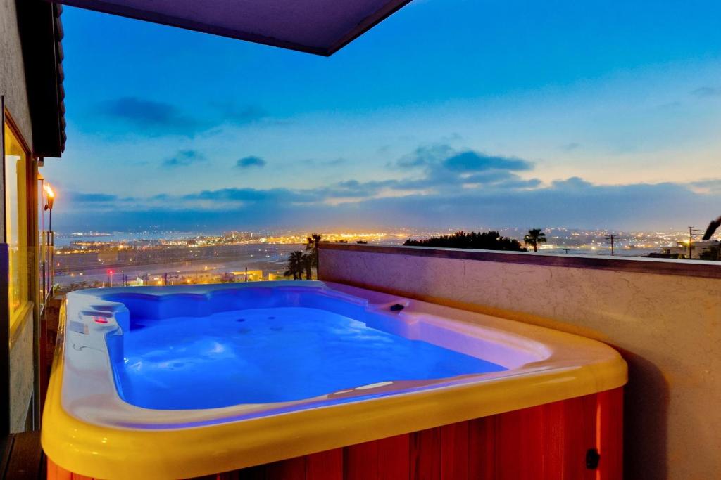 a hot tub on a balcony with a view of the city at Hilltop Hacienda – Private Villa Panoramic Views in San Diego