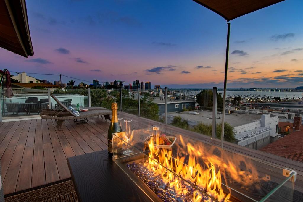 a bottle of wine on a table on a balcony with flames at Luxury Hilltop Retreat in the City - Amazing View in San Diego