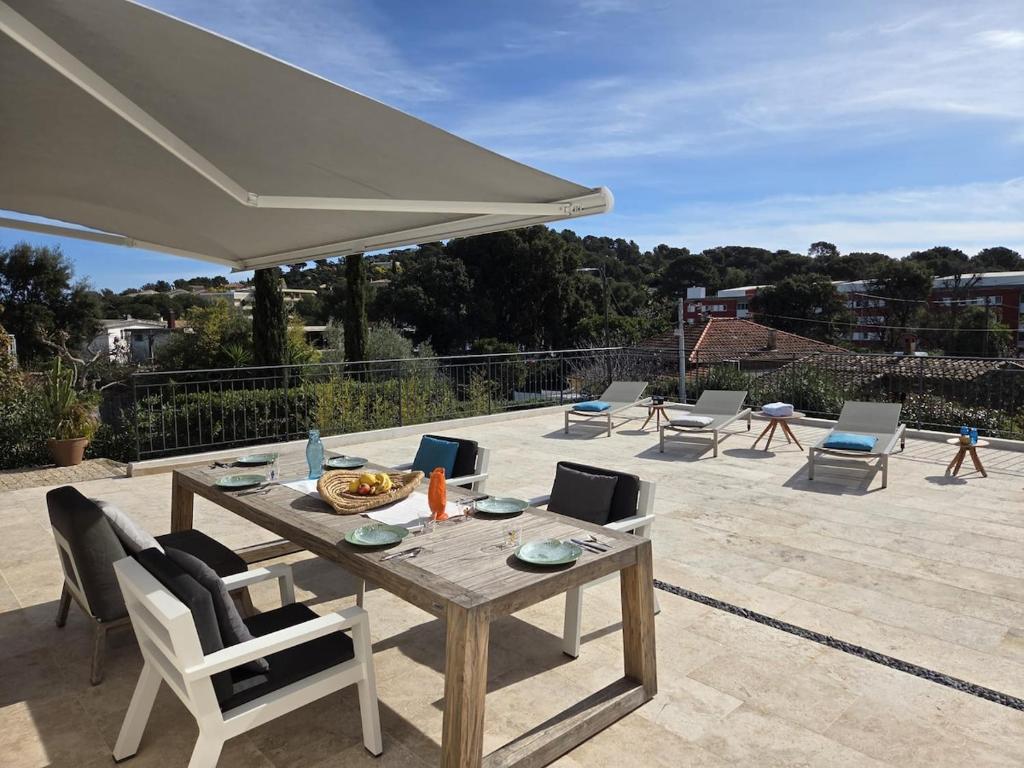 a patio with a table and chairs and an umbrella at Maison Margot Villa provençale a 300m de la plage in Cavalaire-sur-Mer