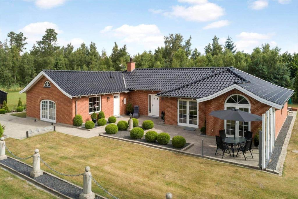 una casa in mattoni rossi con tavolo e ombrellone di M392-Gedser-Havrevej-6 a Gedesby