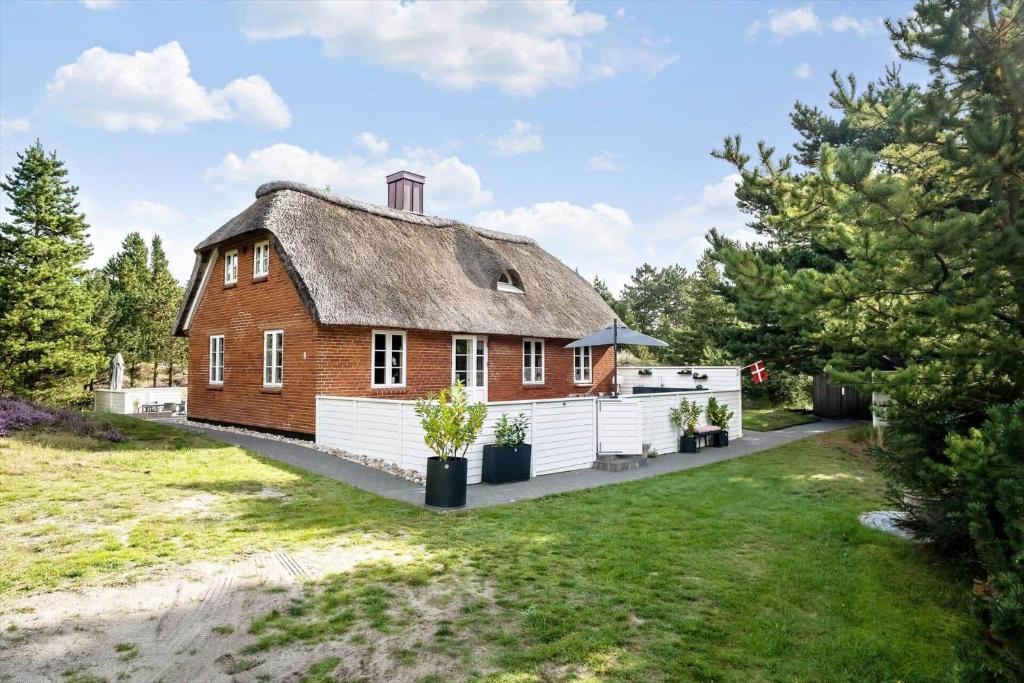 una casa con techo de paja y patio en 2805-Romo-A-Hveyselsvej-8, en Vesterhede