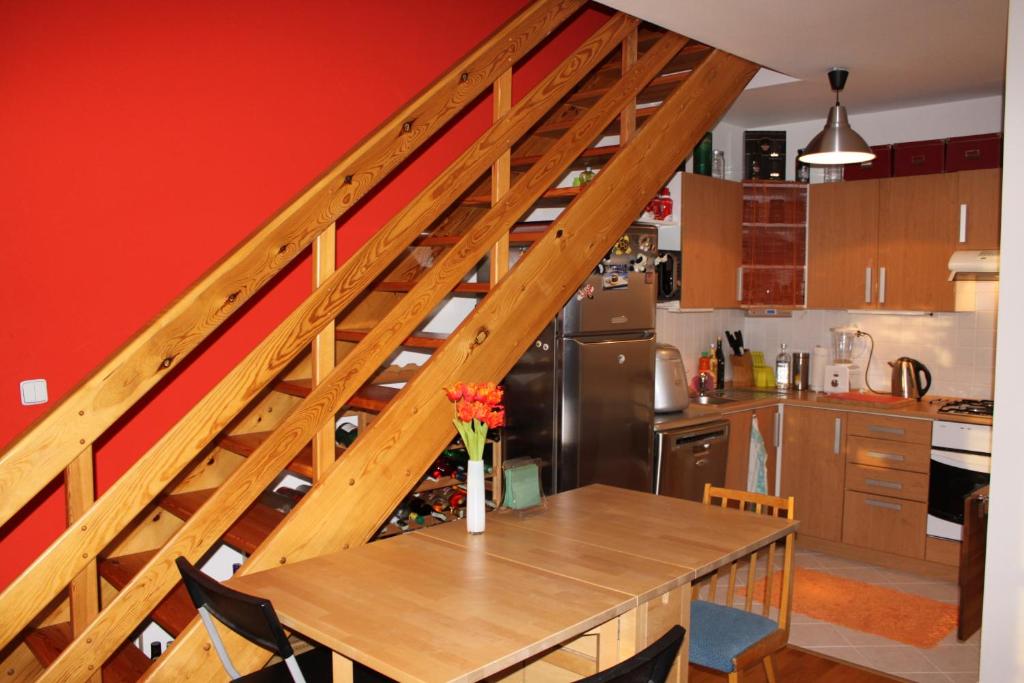 una cocina con una mesa de madera y una escalera en Sunny Two-story Apartment Kyje en Praga