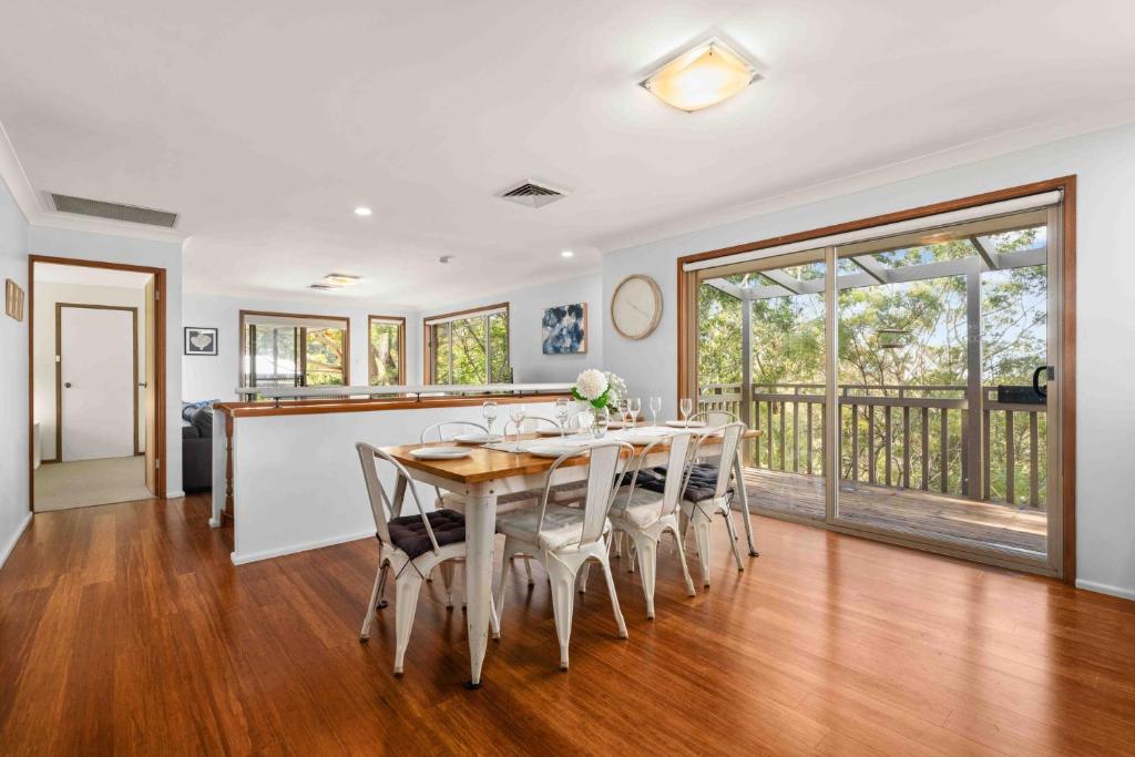 a kitchen and dining room with a table and chairs at Blenheim Hideaway by Experience Jervis Bay in Vincentia