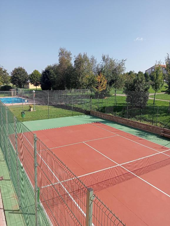 a tennis court with a net in a park at Alojamiento AJO con piscina y tenis - Ajo Palace in Ajo
