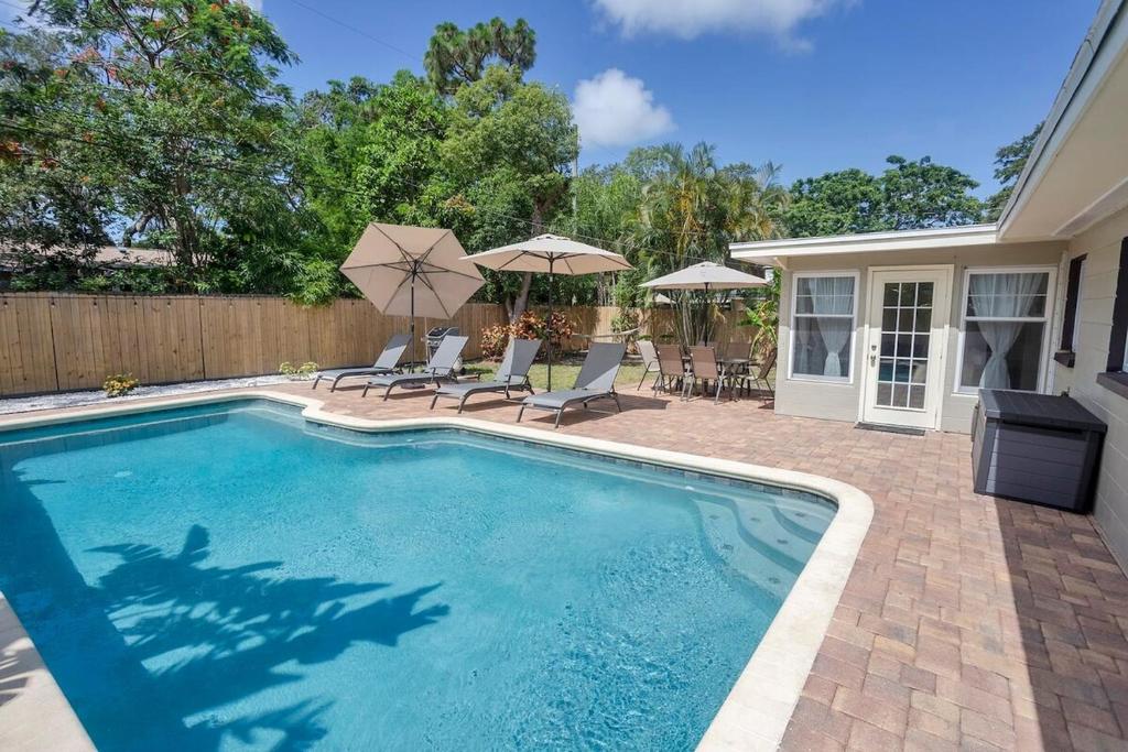 ラーゴにあるVilla Bella with Heated Poolの家の隣にある椅子とパラソルのあるプール