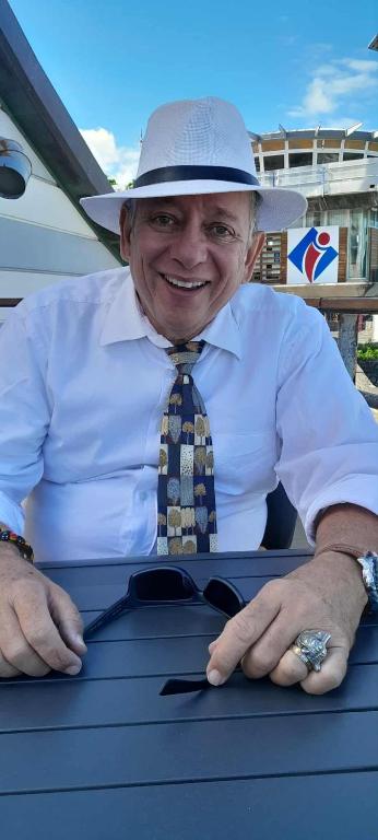 a man wearing a hat and a shirt and tie at appartement Villa Morgane in Saint-Pierre