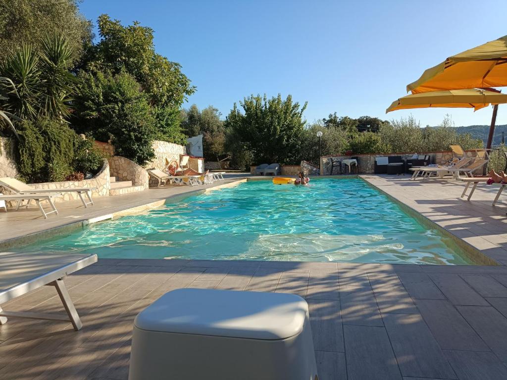 a swimming pool with chairs and an umbrella at Zwei Zimmer Penthouse Wohnung Mit Terrasse Mit Meerblick in Peschici
