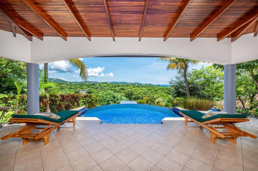 an outdoor patio with chairs and a swimming pool at Vista Oceano in Playa Hermosa