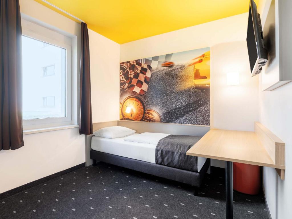 a small room with a bed and a window at B&B Hotel Stuttgart-Zuffenhausen in Stuttgart