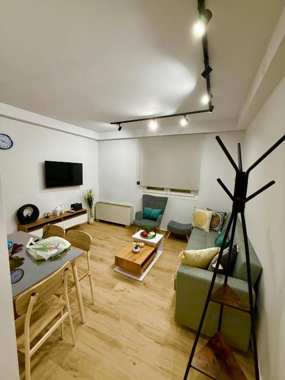 a living room with a green couch and a table at VERORE aprtm in Chalkida