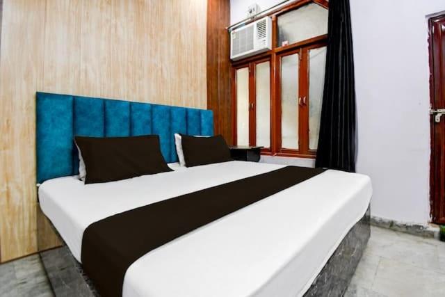een slaapkamer met een groot bed met een blauw hoofdeinde bij Hotel Stay Inn in Lucknow