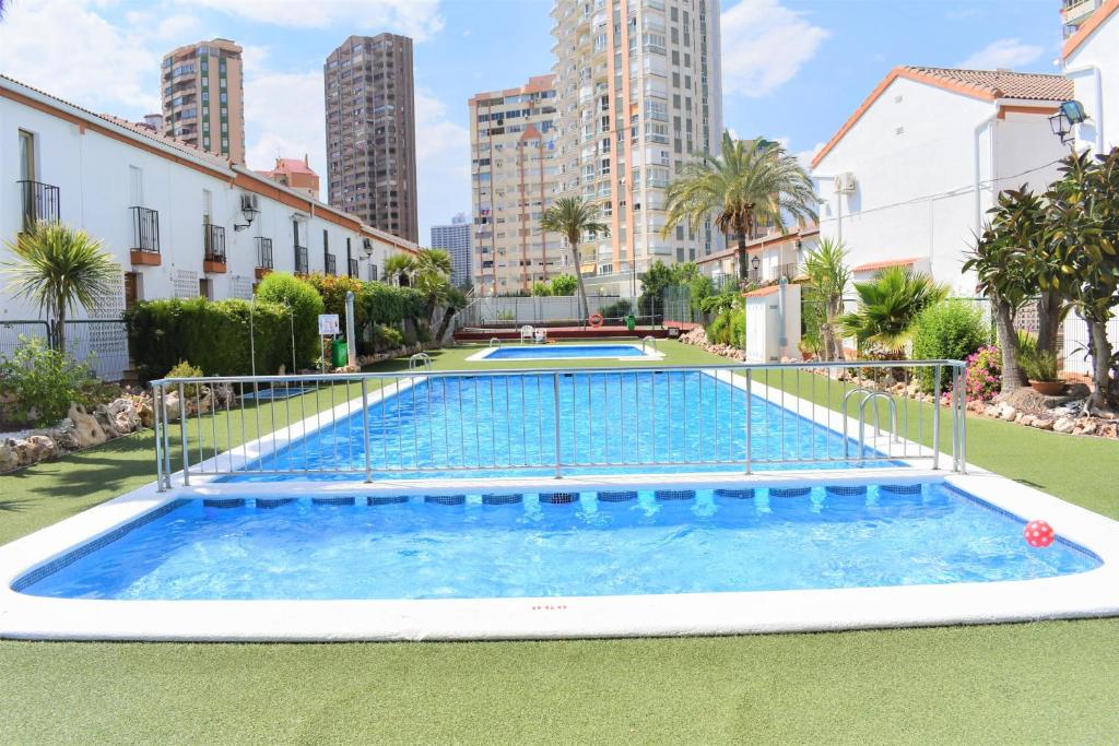 a swimming pool in a city with tall buildings at Ola Azul Bungalow II in Benidorm