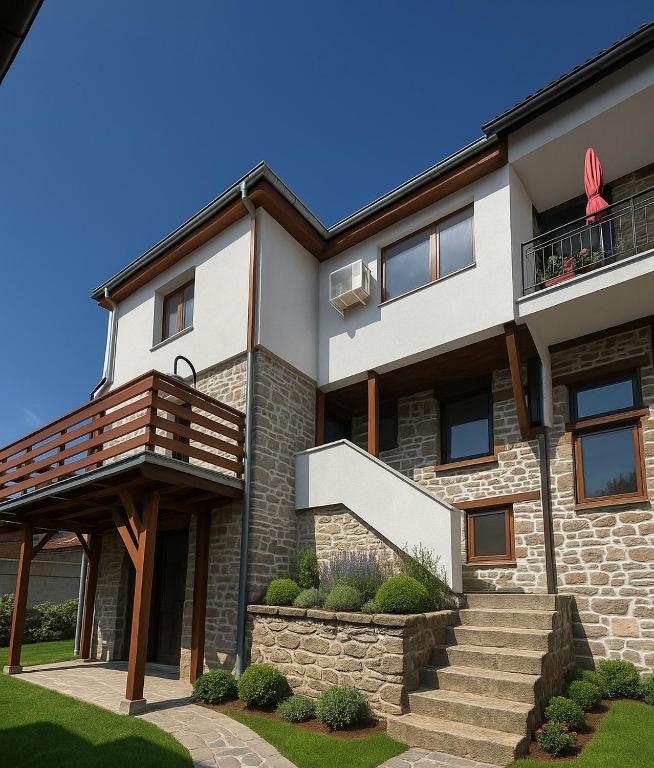 a large house with a balcony and stairs at Mountain Whisper Guesthouse in Smolyan