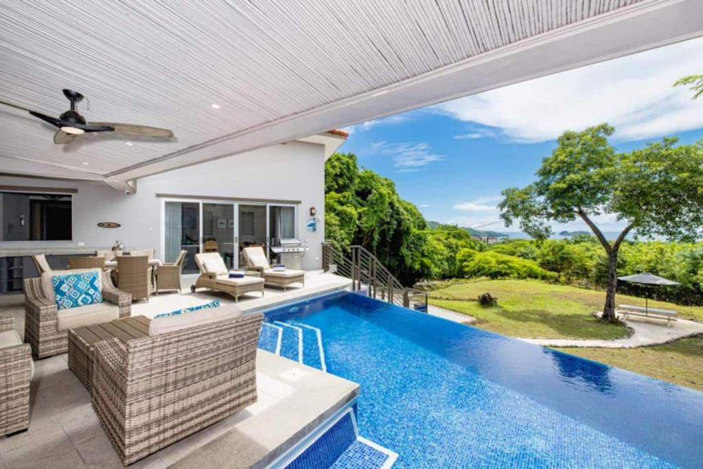 an outdoor living area with a swimming pool and a patio at Amigos De Tortuga in Playa Hermosa