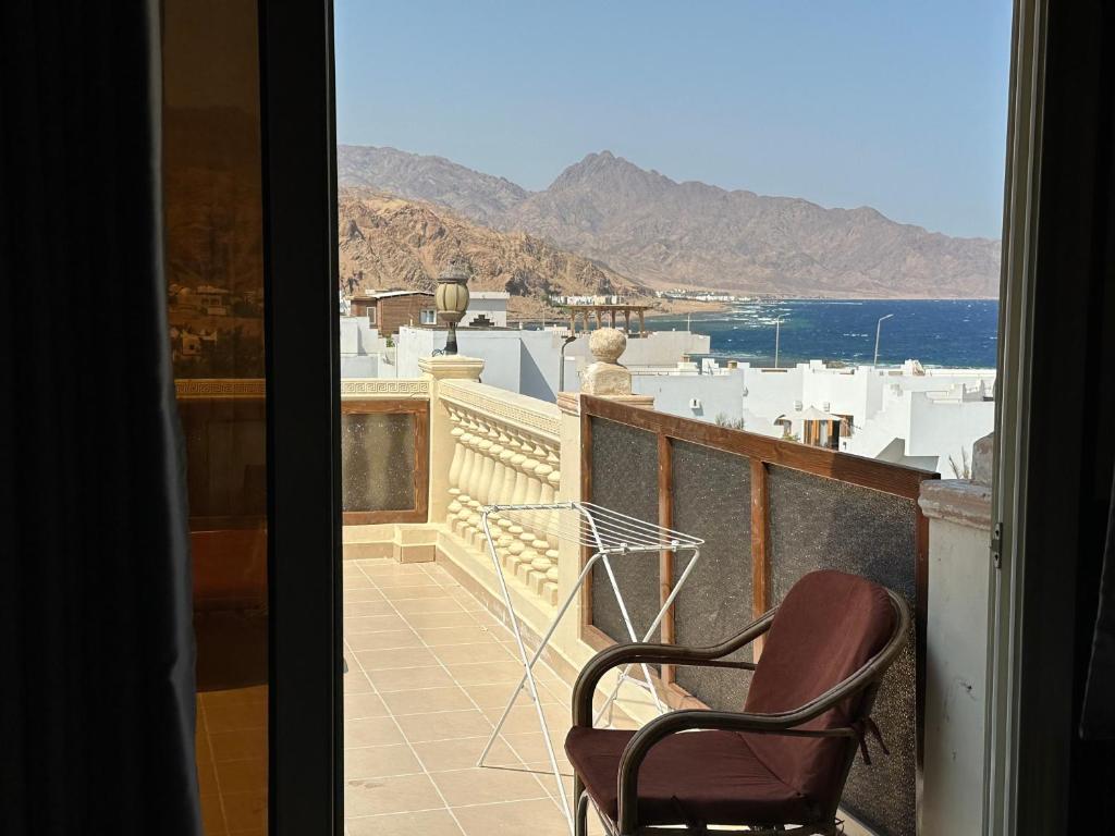Un balcón con dos sillas y vista al mar. en Lucky house dahab, en Dahab