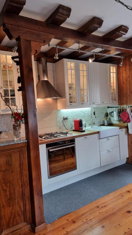 een keuken met witte kasten en een kookplaat oven bij Antica Dimora Dolomiti in Vodo Cadore