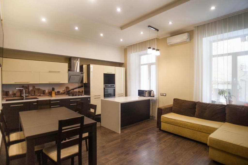 a kitchen and living room with a couch and a table at Апартаменты в центре на Ришельевской in Odesa
