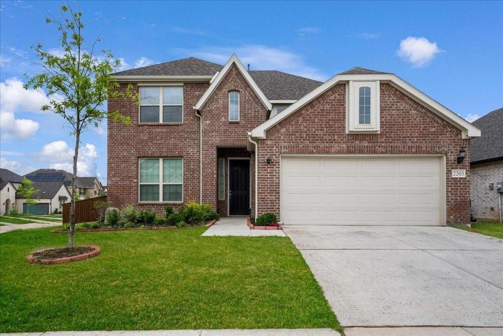 a large brick house with a white garage at Mansfield House Texas in Mansfield