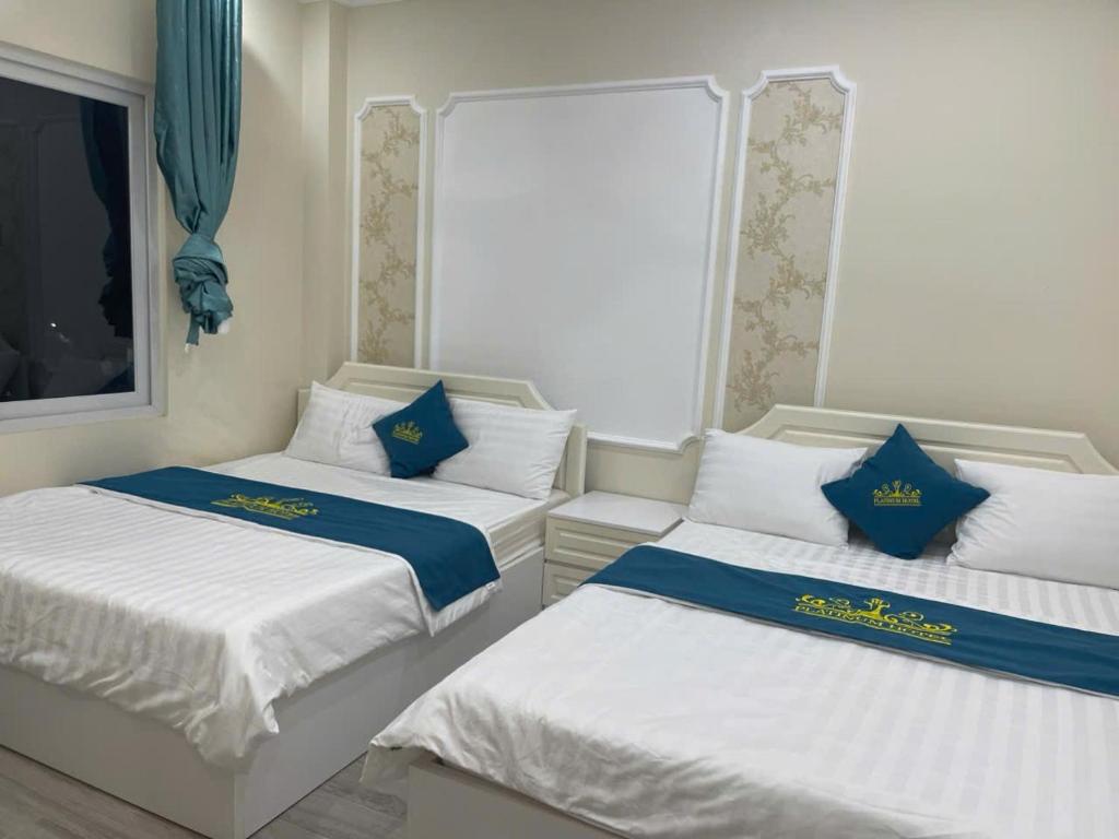 two beds in a room with blue and white at Platinum in Xóm Hương Phùng