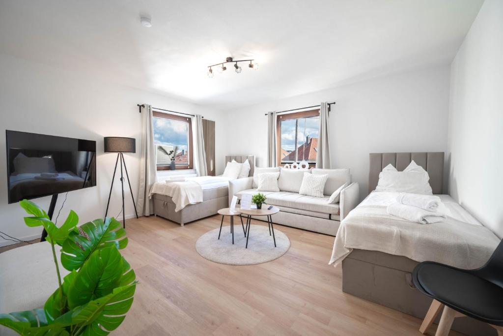 a white room with a bed and a couch at Malu Rooms - Attraktive Lage, Balkon, SmartTv, 24h Checkin, Waschmaschine, in Ludwigsburg