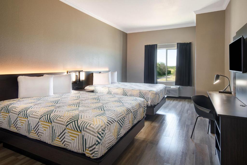 a hotel room with two beds and a desk at Motel Worth, TX in Fort Worth