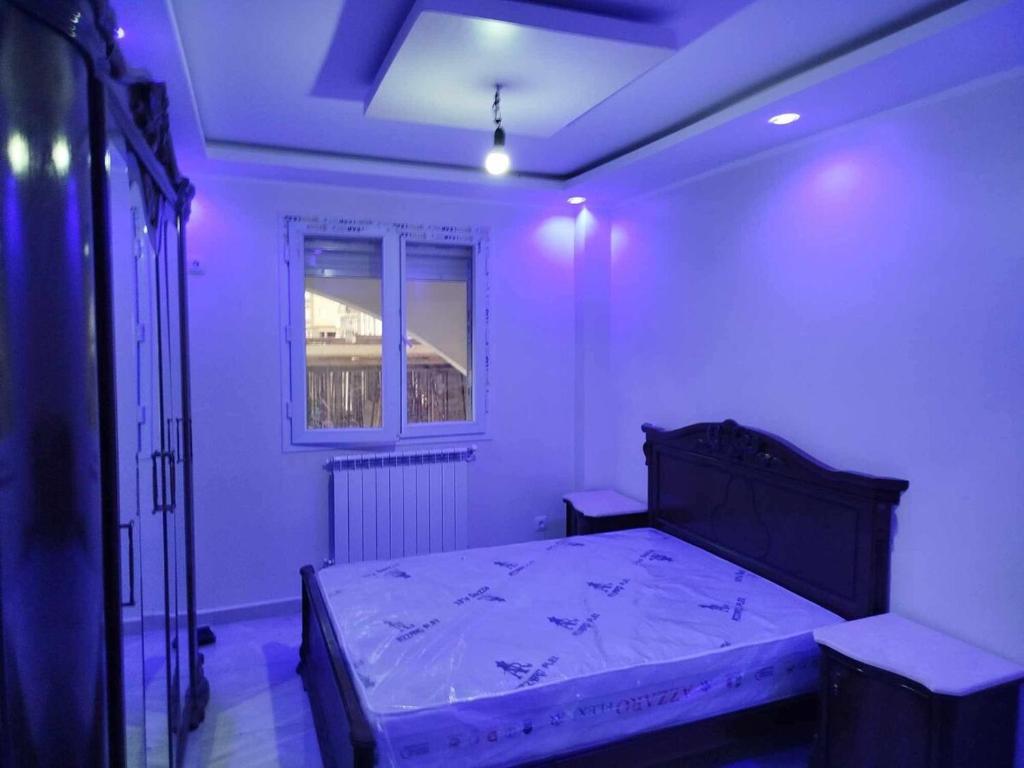 a bedroom with a bed in a room with purple lights at Apartment f2, 58 m situé a kaktakit Boumerdes in Boumerdes
