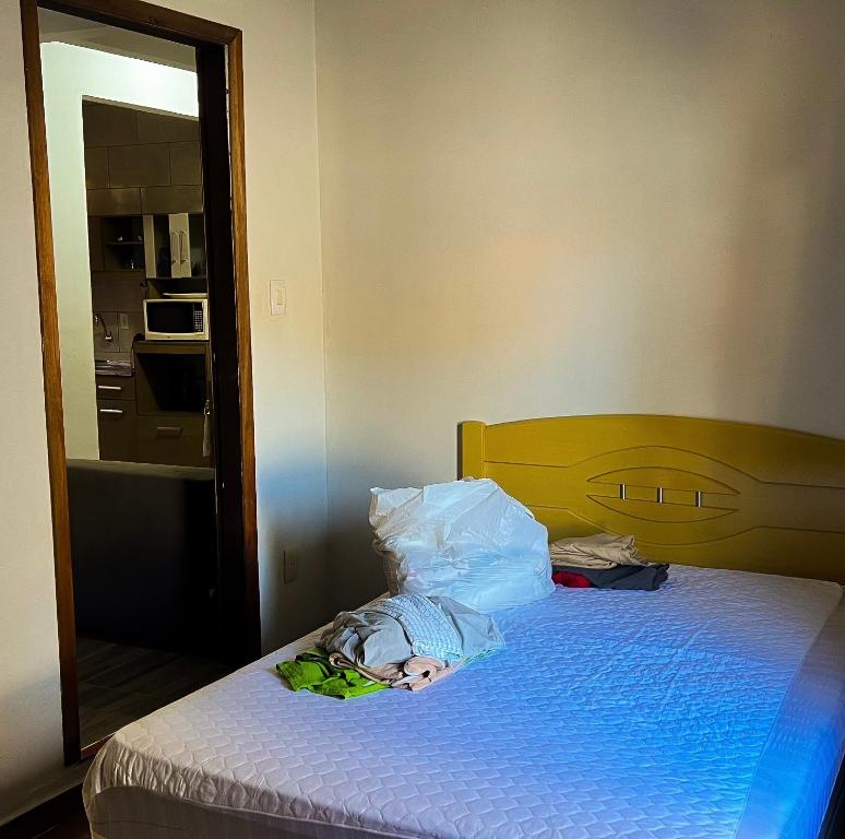 a bedroom with a bed with a pile of clothes on it at Apartamento no Andar Inferior na Praia da Vila em Imbituba in Imbituba