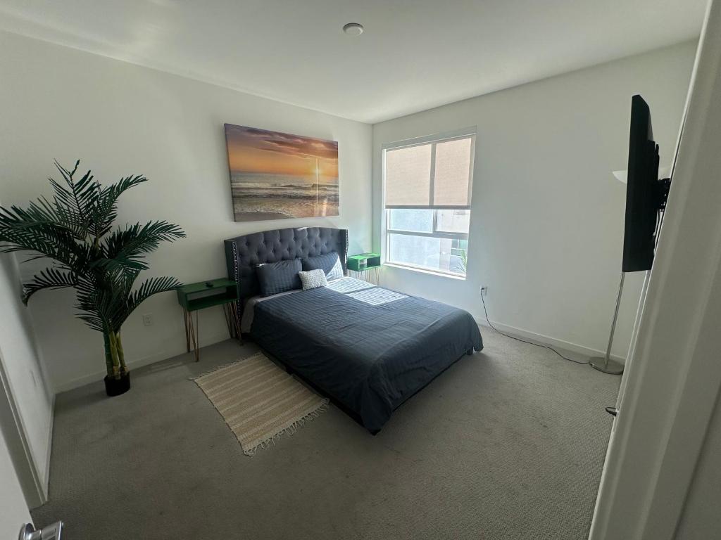 Un dormitorio con una cama y una planta en maceta. en 2BR w parking located DTLA!!, en Los Ángeles