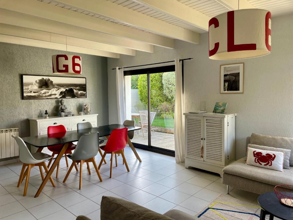 ein Wohnzimmer mit Esstisch und Stühlen in der Unterkunft L'Abri du Rouget, 5 minutes à pied de la plage du Trez-hir, vacances en famille in Plougonvelin