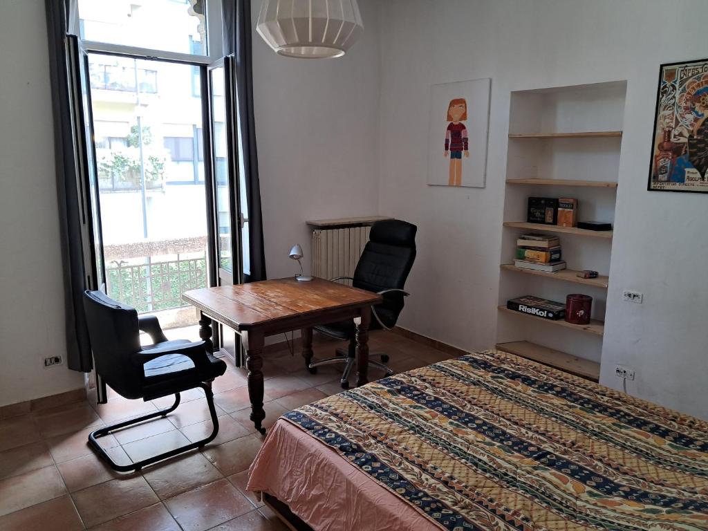 Un dormitorio con un escritorio, una mesa y una cama. en Dario's Trumpet, en Milán