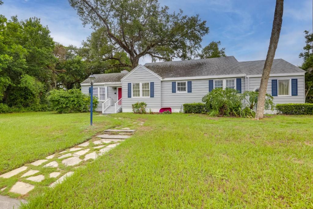 una casa blanca con una puerta roja y un patio en 4 Mi to Jetty Park Beach! Family Home with Game Room, en Fort Pierce