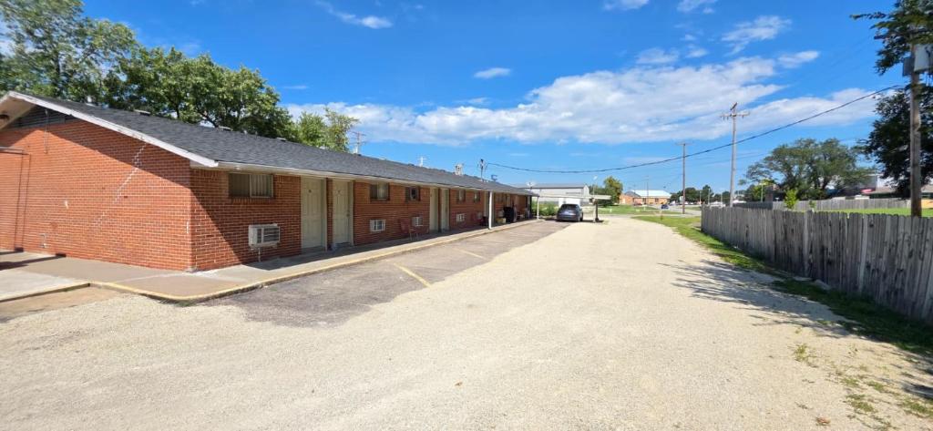 a red brick building with a fence next to a road at Country Inn Marion in Marion