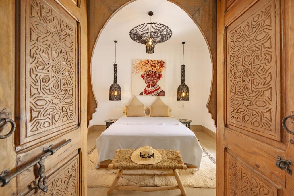 une chambre avec un lit avec un tableau sur le mur dans l'établissement Riad Amaya, à Marrakech