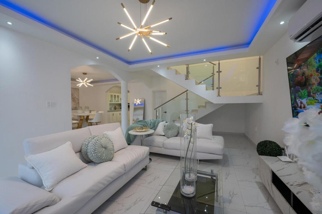 a living room with white furniture and a blue ceiling at Summer Shades Villa at Legacy in Montego Bay