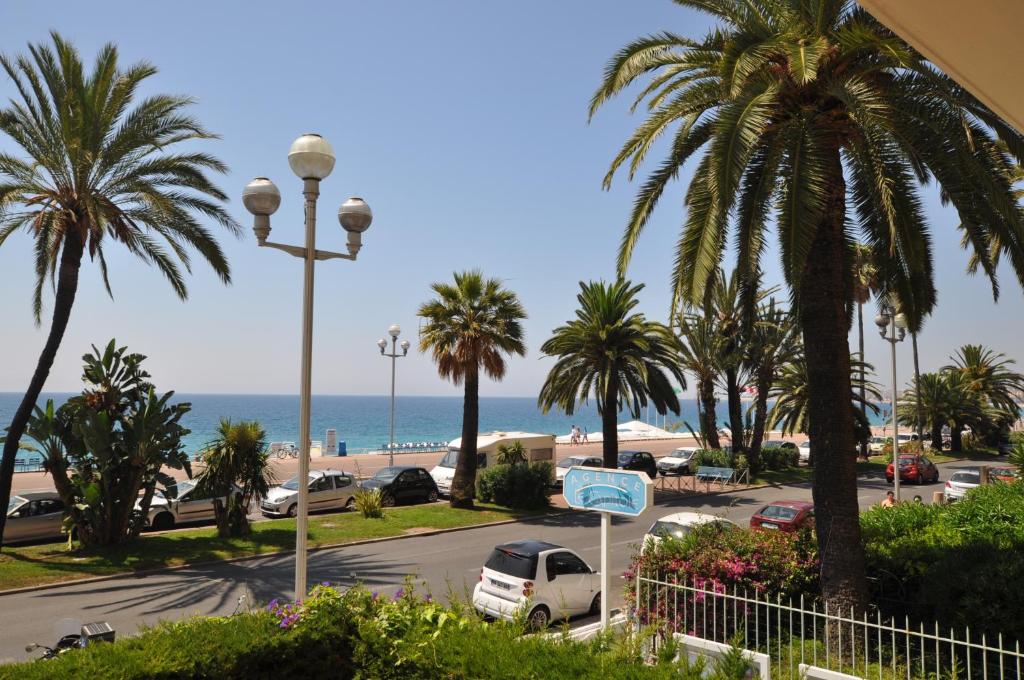 a view of a parking lot with palm trees and the ocean at Appartement 53 Promenade des Anglais in Nice
