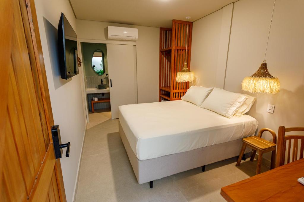 a small bedroom with a bed and a table at Savana Suítes in São Paulo