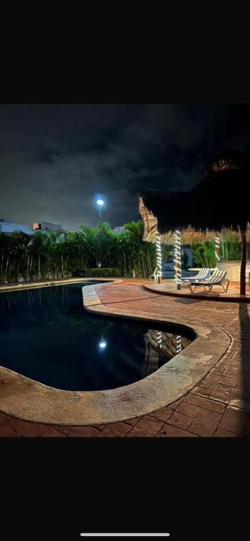 a swimming pool with an umbrella and a gazebo at Casa Vallarta in Cedro