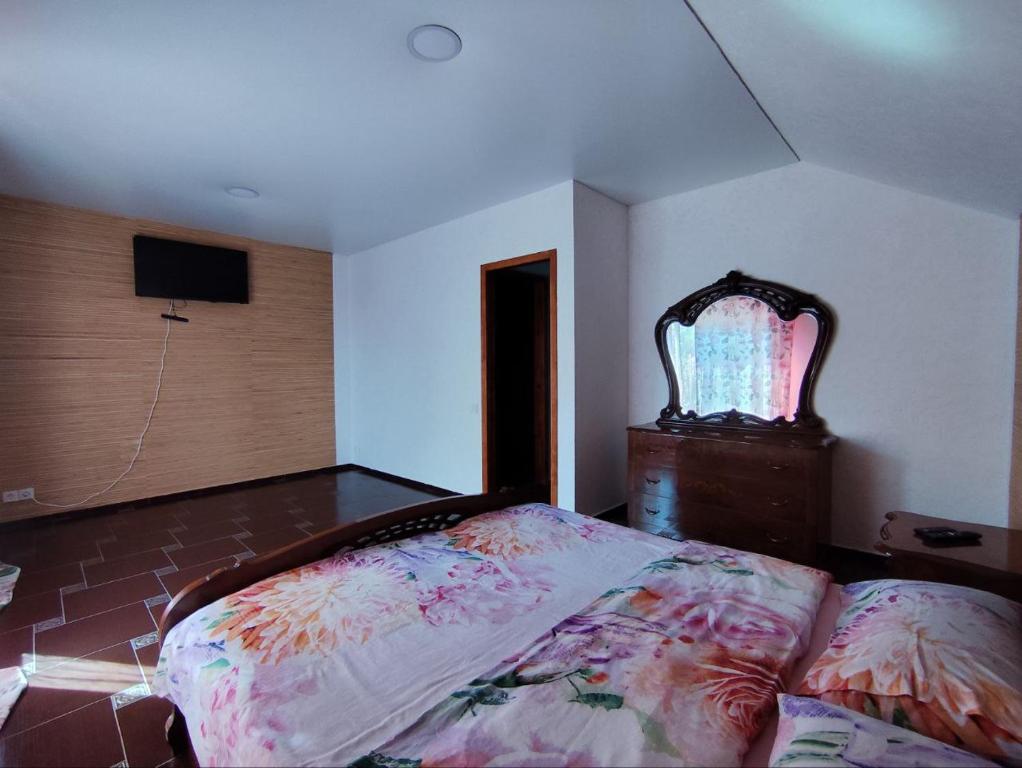 ein Schlafzimmer mit einem Bett und einem Fernseher an der Wand in der Unterkunft Сучасна 2-кімнатна квартира-студія in Dnipro