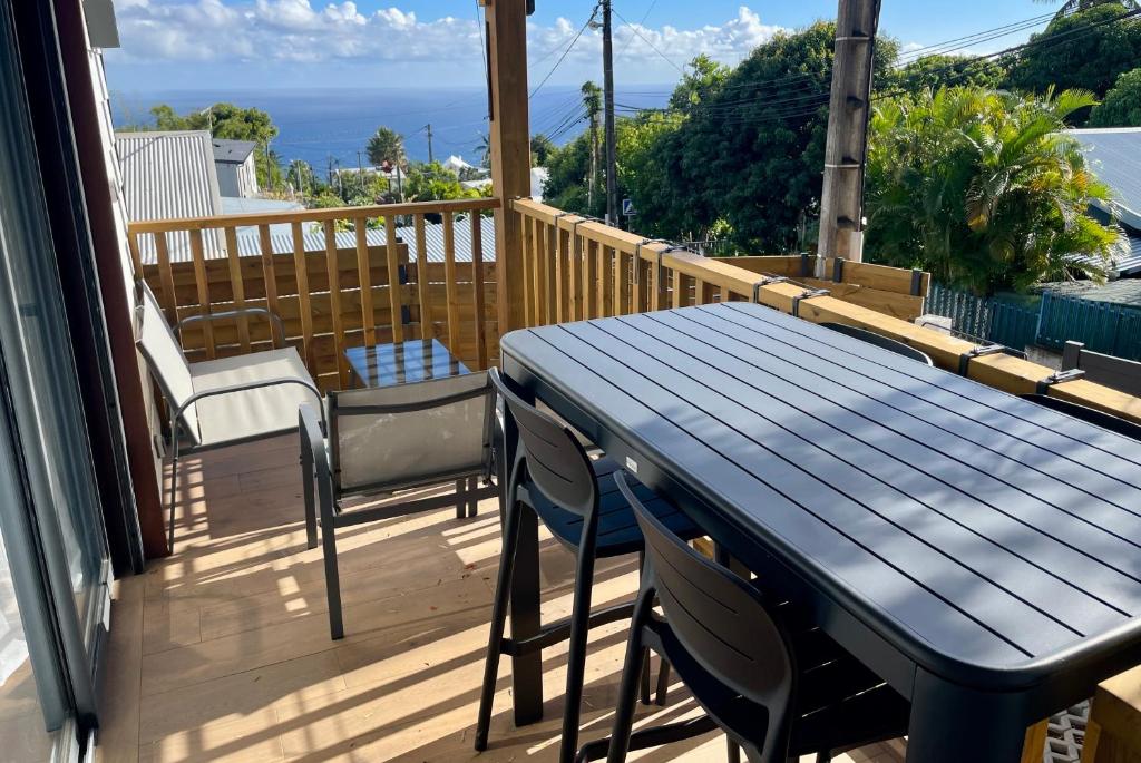 a blue table and chairs on a balcony with the ocean at La Kazadoo in Piton Saint-Leu