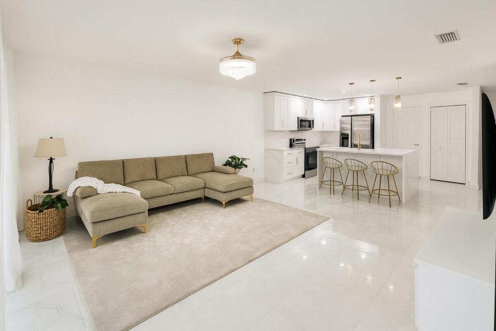 ランドオレイクスにあるLuxury Modern Retreat 5 Minutes to Tampa Outletのソファと椅子、キッチンのあるリビングルーム