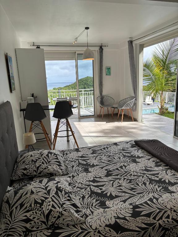 a bedroom with a bed and a view of the ocean at EDEN-RÉSIDENCE Le ARUBA Vue Mer et Piscine in Sainte-Luce