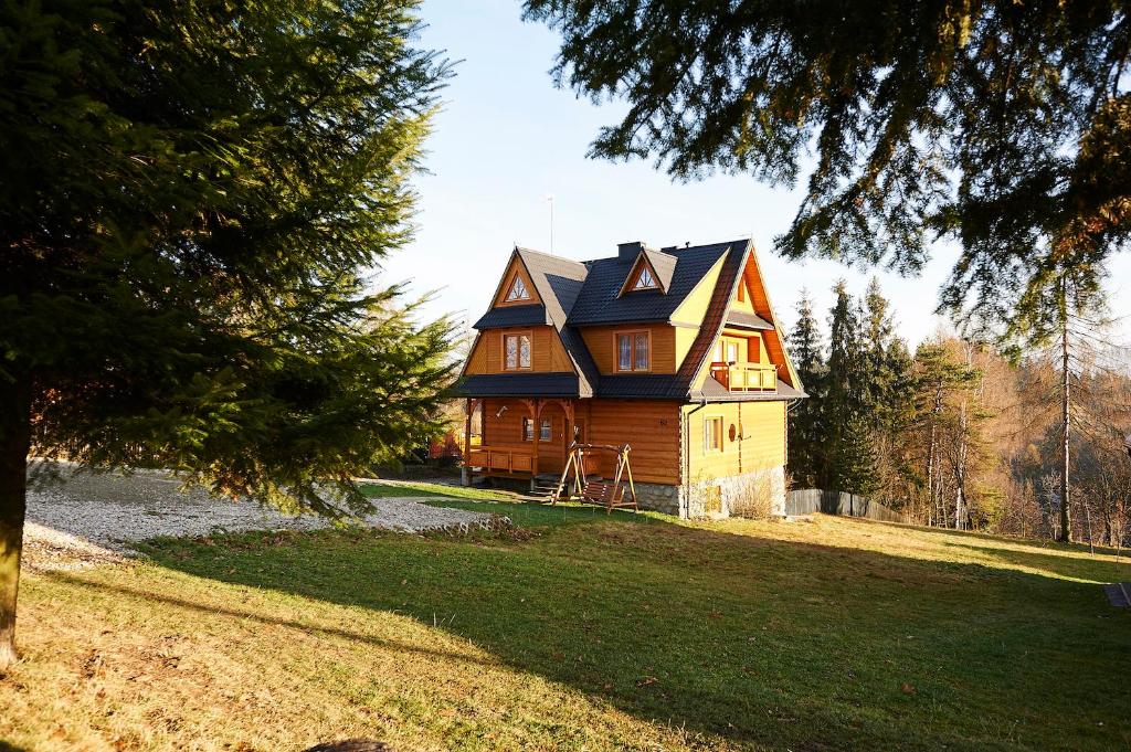 a large wooden house with a gambrel roof at Noclegi u Hanki in Bukowina Tatrzańska