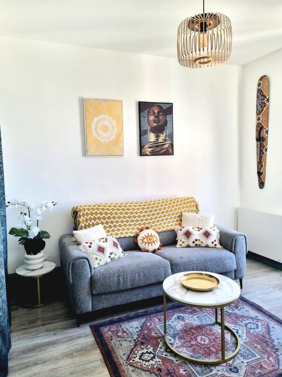 a living room with a couch and a table at Le Globe Trotters in Saint-Étienne