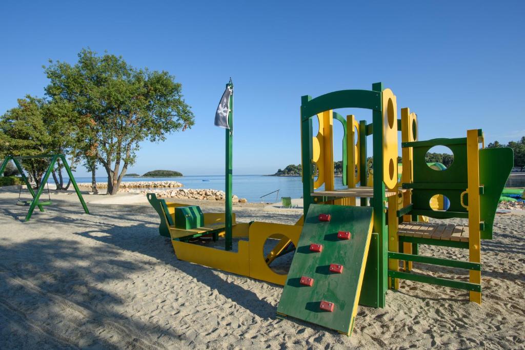 a playground with a slide on a beach at Maistra Camping Valkanela Mobile homes in Funtana