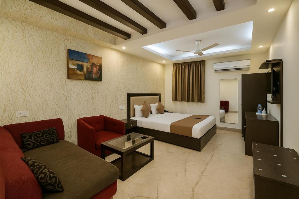 une chambre d'hôtel avec un lit et un canapé dans l'établissement Hotel Kingston Park, Karol Bagh, New Delhi - 2 Mins from Metro, à New Delhi