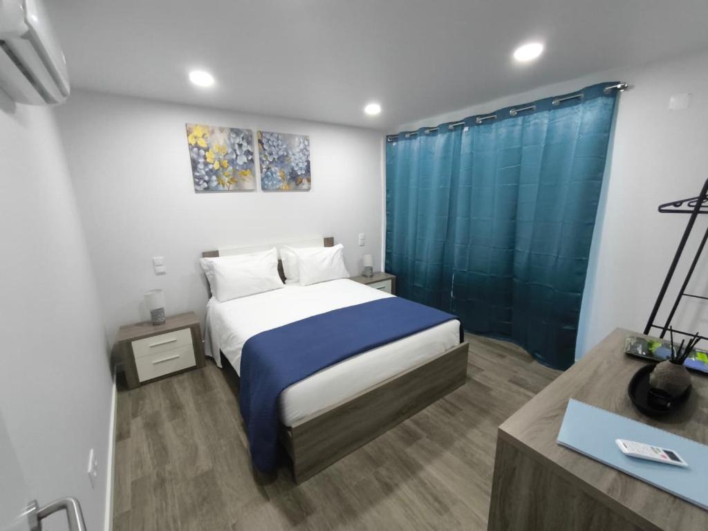 a bedroom with a bed and a blue shower curtain at Flor da Natureza - Flor in Pilar