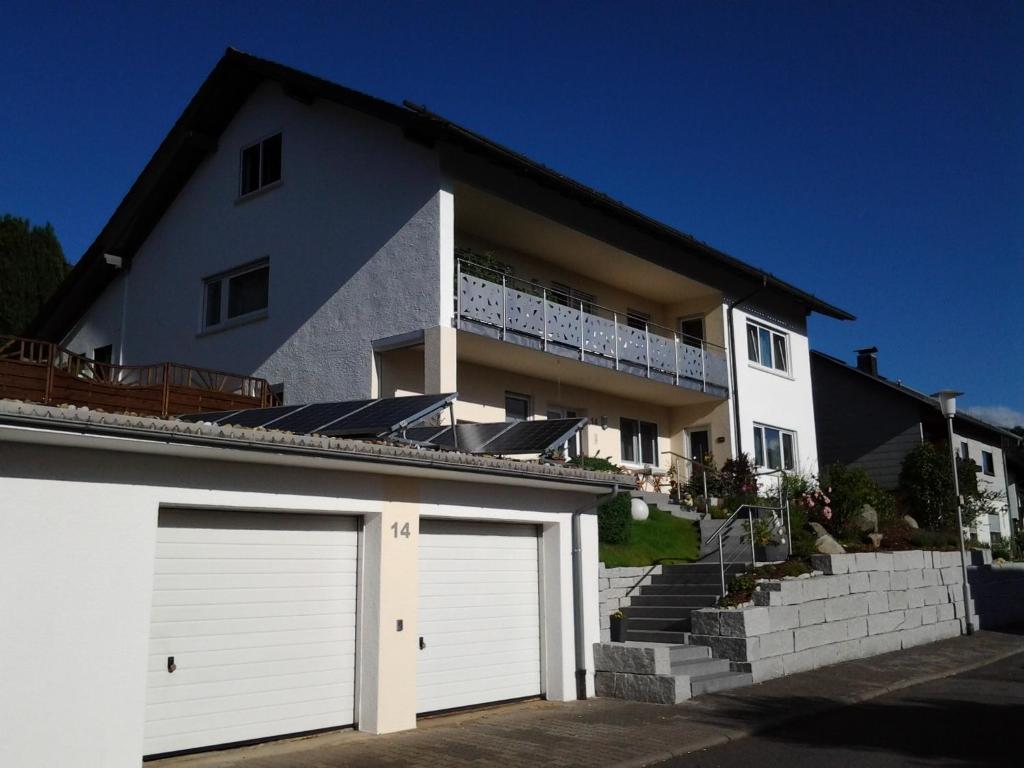 una casa blanca con dos puertas de garaje delante en Ferienwohnung Ehret en Wald-Michelbach