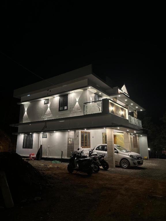 a building with a motorcycle parked in front of it at night at Rambos Inn Homestay in Vagamon
