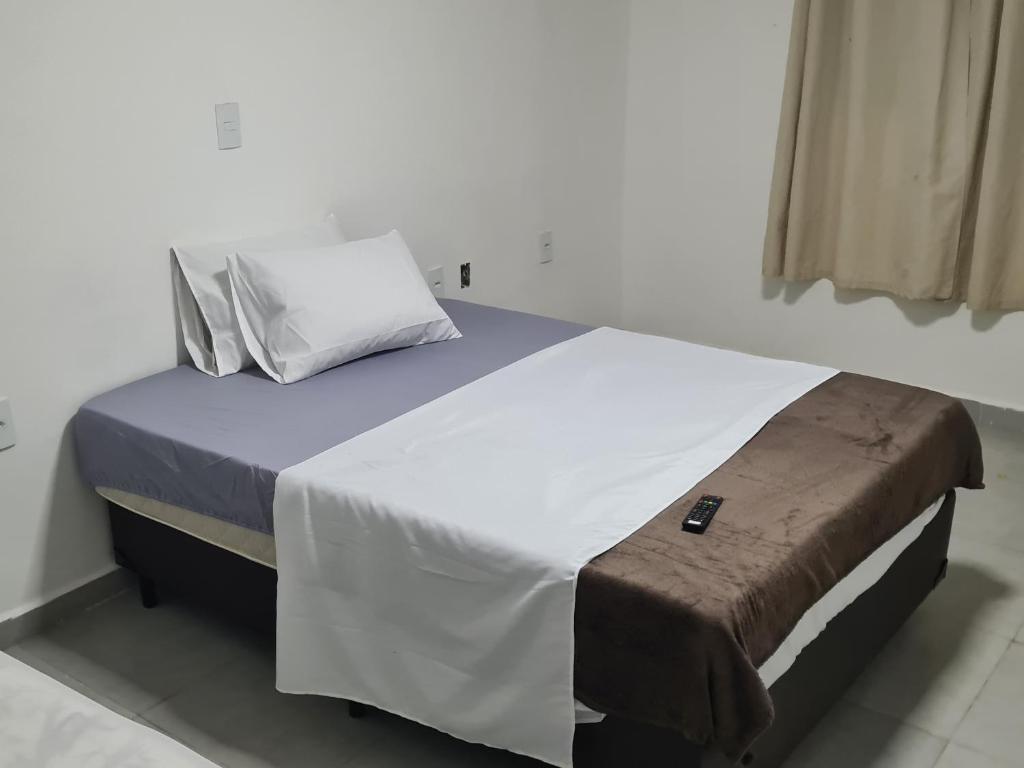 a bedroom with a large bed with white sheets and pillows at Hotel Rei in São Bernardo do Campo