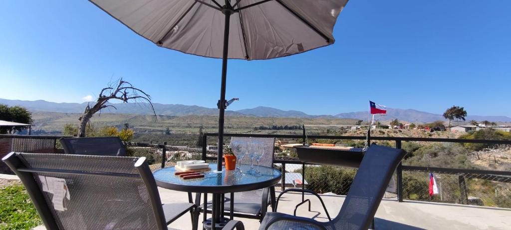 a patio with a table and chairs and an umbrella at Casa Turismo Freirina in Freirina